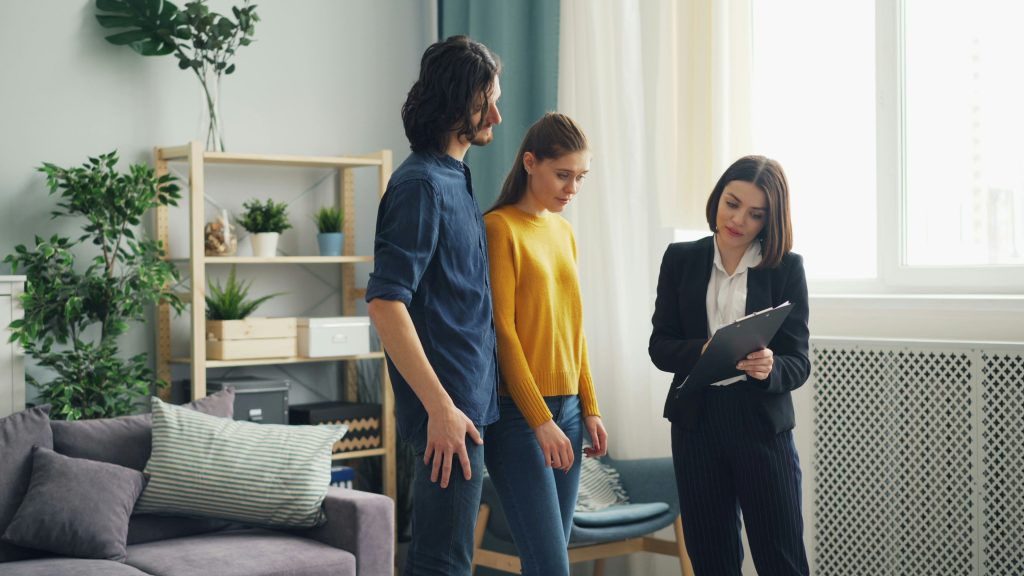 Couple reviewing inspection report with a home inspector holding a clipboard