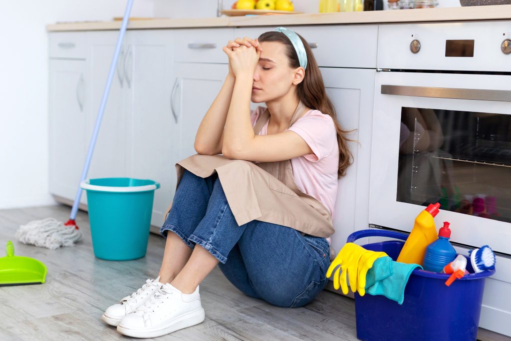Exhausted homeowner cleaning their house while preparing it for sale